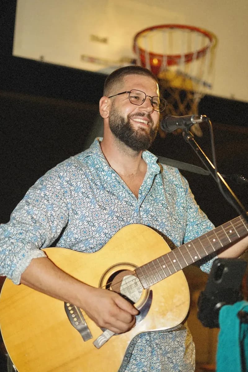 Gitarist svira ispod koša na večernjoj svirci